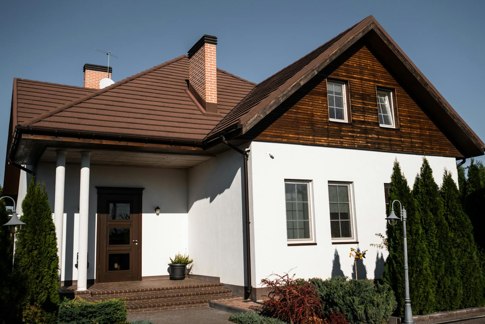 Charming modern bungalow with white facade and brown roof, ideal for architectural themes.